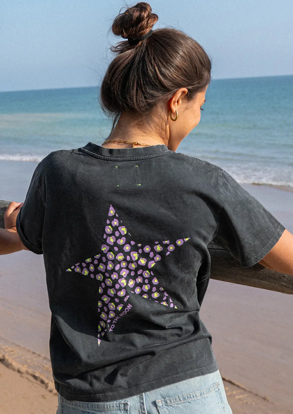 Espalda de Camiseta manga corta de To the Moon en color negro con estampado estrella animal print en lila y amarillo flúor.