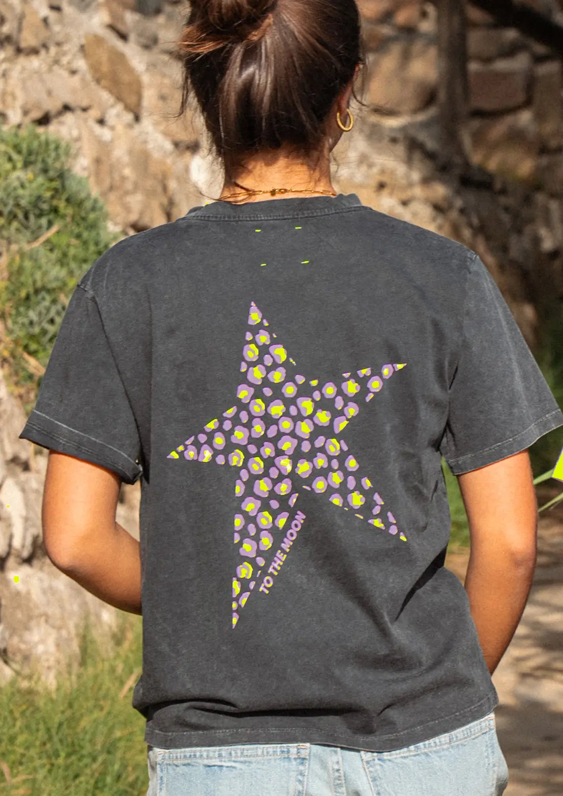 Espalda de Camiseta negra manga corta de To the Moon con estampado estrella animal print en lila y amarillo flúor.