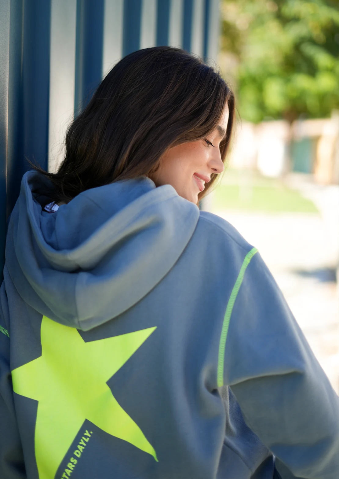 Hoodie de To the Moon en color gris con capucha y bolsillo canguro. SerigrafĂa trasera amarillo flĂșor con estrella y frase "Chasing Stars Daily".