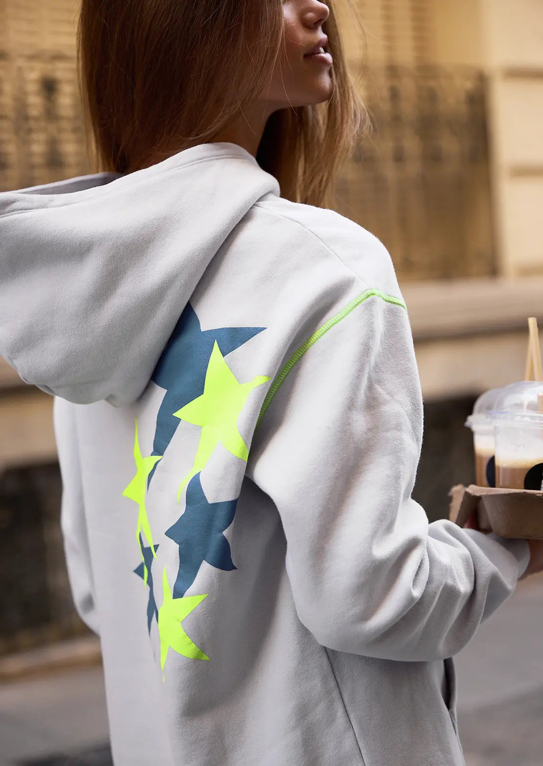 La sudadera cosmos ice grey de la temporada con capucha y bolsillo canguro de To the Moon. Serigrafía amarillo neón y gris de estrellas en la espalda y bordado de marca en parte delantera.