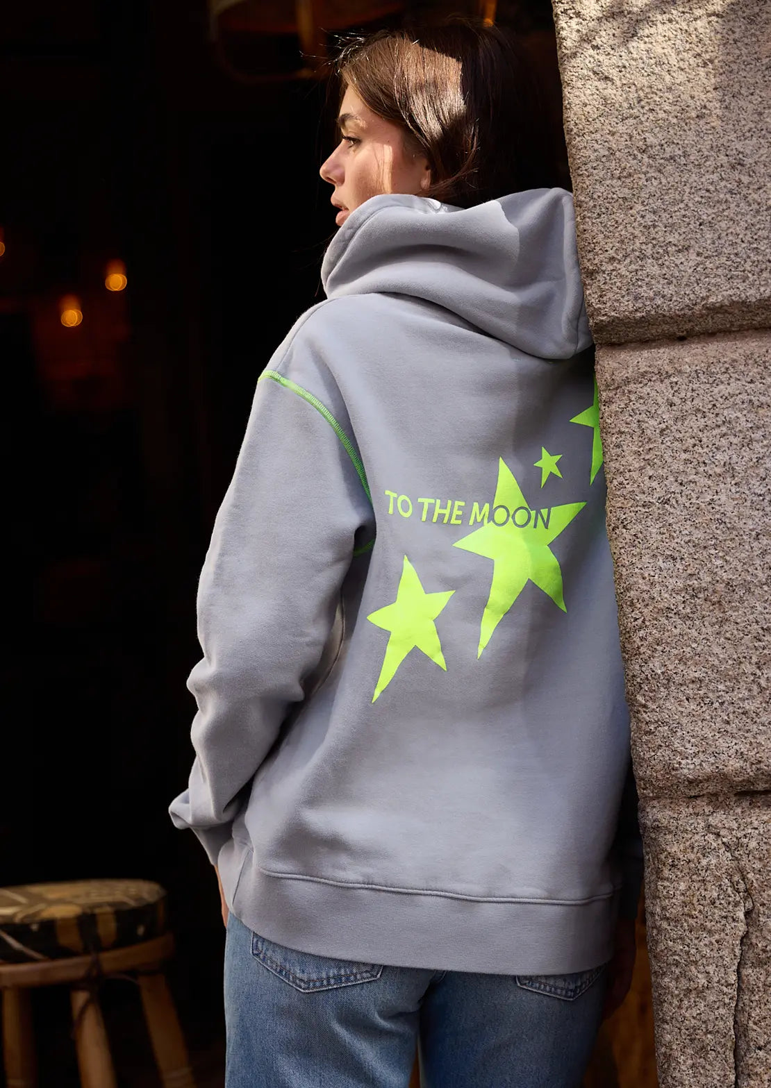 La sudadera gris de la temporada con capucha y bolsillo canguro de To the Moon. Serigrafía amarillo neón estrellas y bordado de marca en parte delantera.