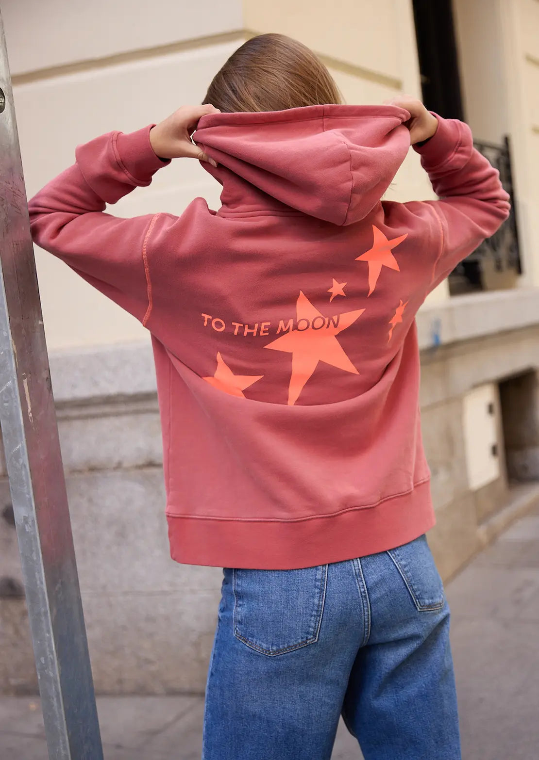 La sudadera roja de la temporada con capucha y bolsillo canguro de To the Moon. Serigrafía naranja neón estrellas y bordado de marca en parte delantera.