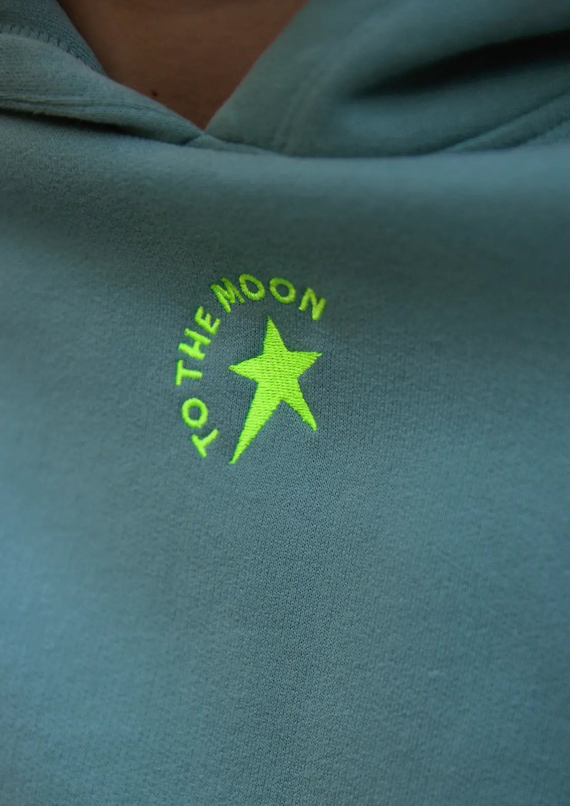 Comprar sudadera de To the Moon en color azul petróleo pantone Oil Blue con capucha y bolsillo canguro. Estrellas serigrafía amarillo flúor y gris.