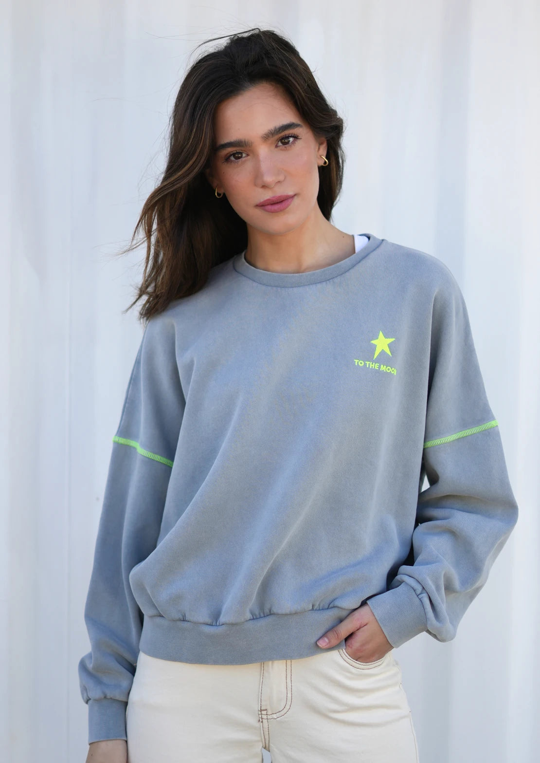 Sudadera ideal para teens en gris claro de To the Moon. Bordado delantero y serigrafía trasera costuras en amarillo flúor.