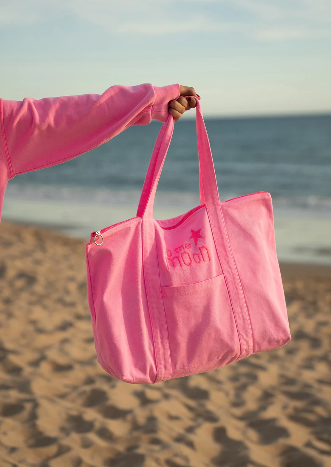 Bolsa de playa en color rosa neon multiusos con cremallera  y bolsillos para ir a la playa.