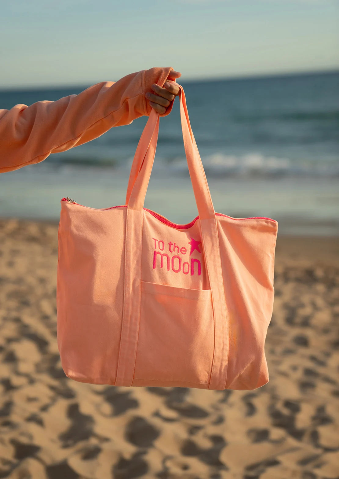 Bolsa de playa en color salmón neon multiusos con cremallera  y bolsillos para ir a la playa.
