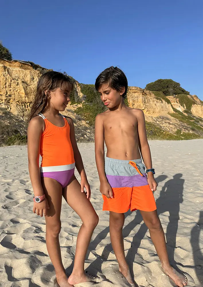 Hermanos a juego con el bañador Naranja Flúor para niña y el bañador para niño Surf Naranja Flúor