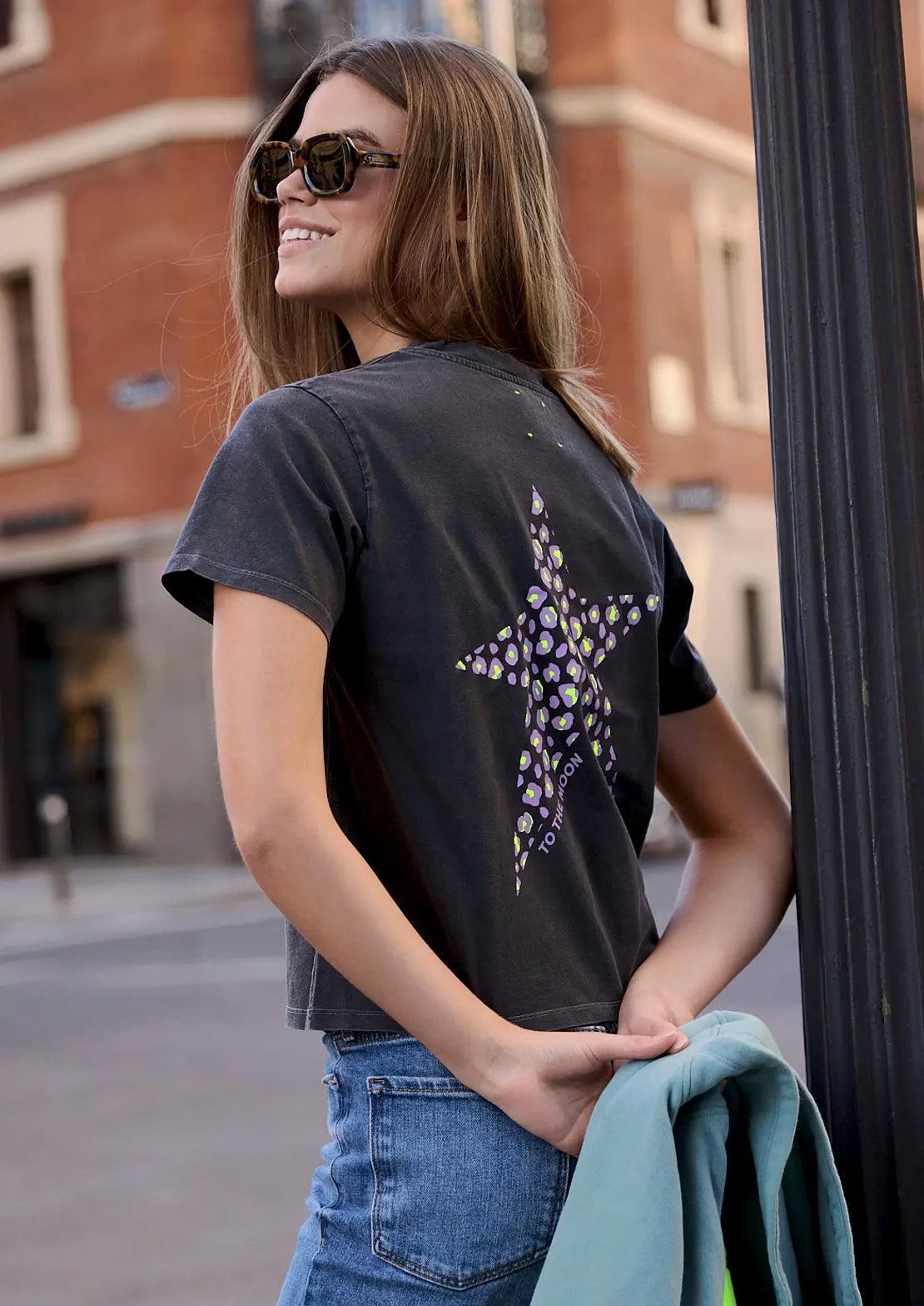 Parte trasera de Camiseta manga corta de To the Moon en color negro con estampado estrella animal print en lila y amarillo flúor.