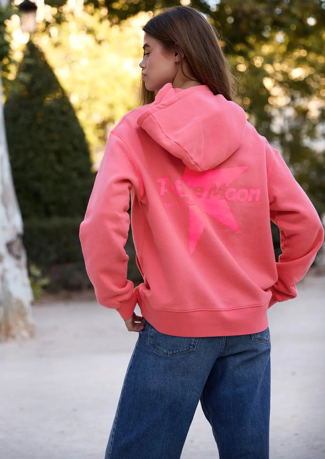 Hoodie color coral estrella fucsia flúor con capucha y bolsillo canguro ideal para teens de To the Moon. Estrella  fucsia flúor serigrafiadas en la espalda.

